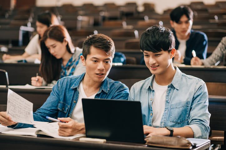 Two male students in class learning together