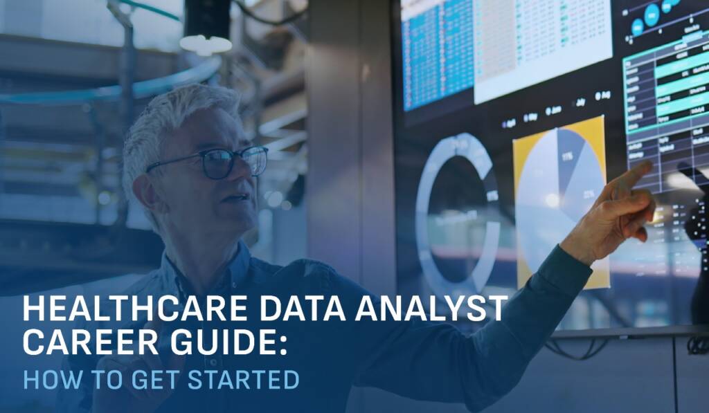 a man with glasses and white hair points to a screen with charts and graphs on it in a business setting