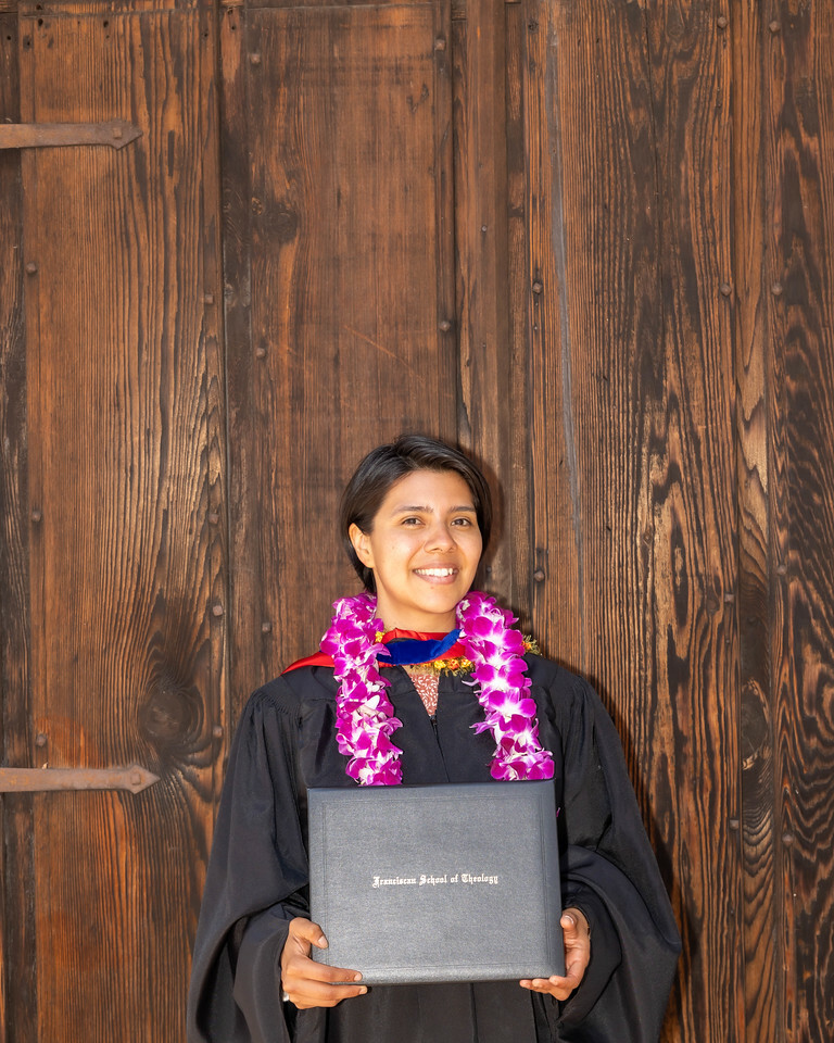 A woman proudly holds her diploma, symbolizing her academic achievement and dedication to her education.