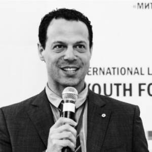 black and white photo of a man speaking into a microphone