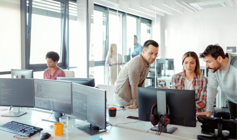 Startup business and entrepreneurship problem solving. Young AI programmers and IT software developers team brainstorming and programming on desktop computer in startup company share office space.