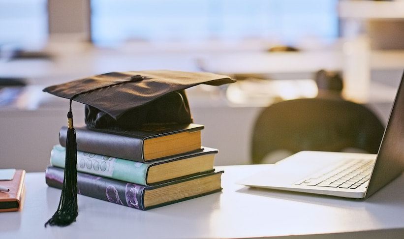 Graduation cap, books and laptop or university education for future goal, scholarship or online. Studying, research and thesis proposal for final school project for learning course, report or student.