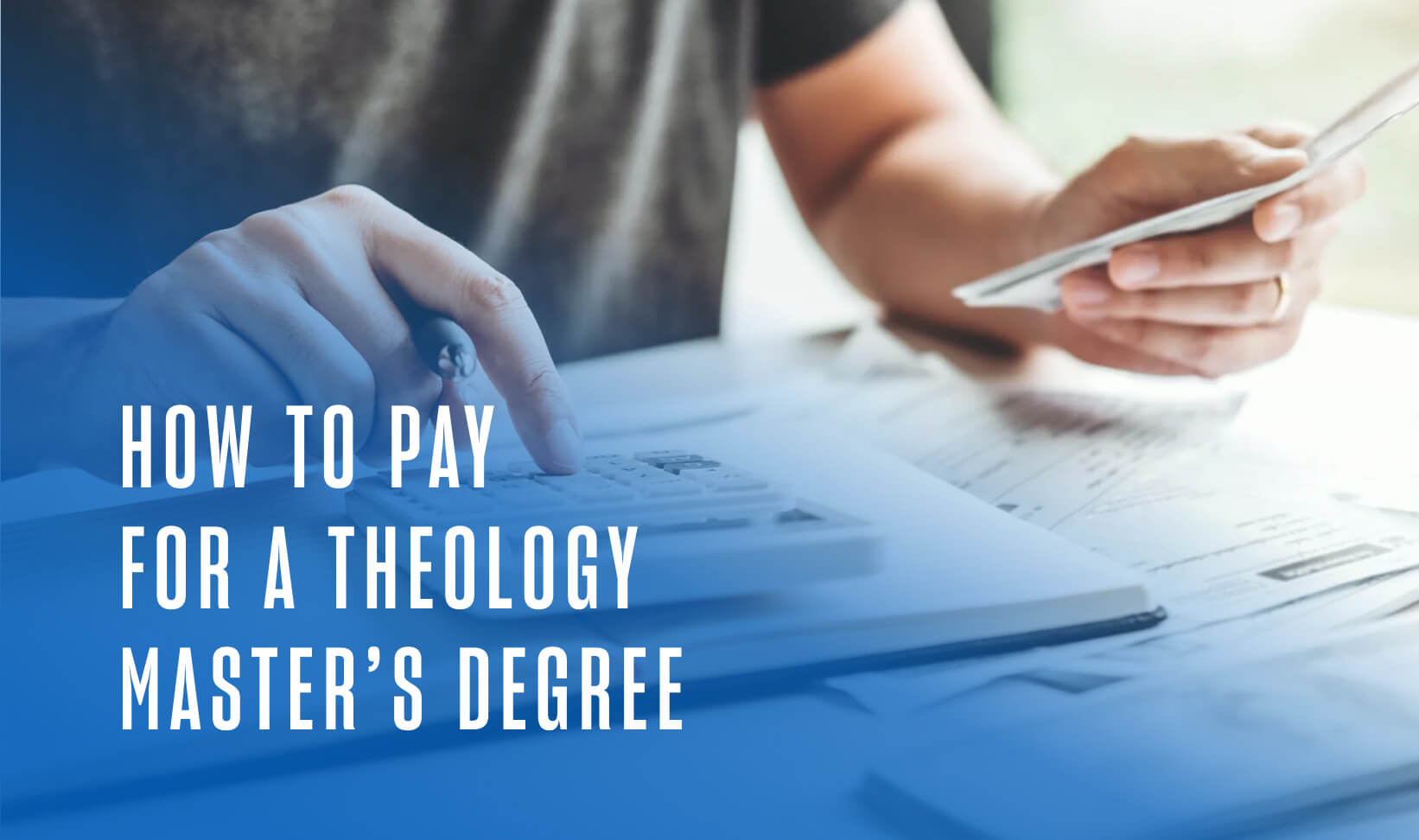 A close-up of someone using a calculator with a stack of bills next to them