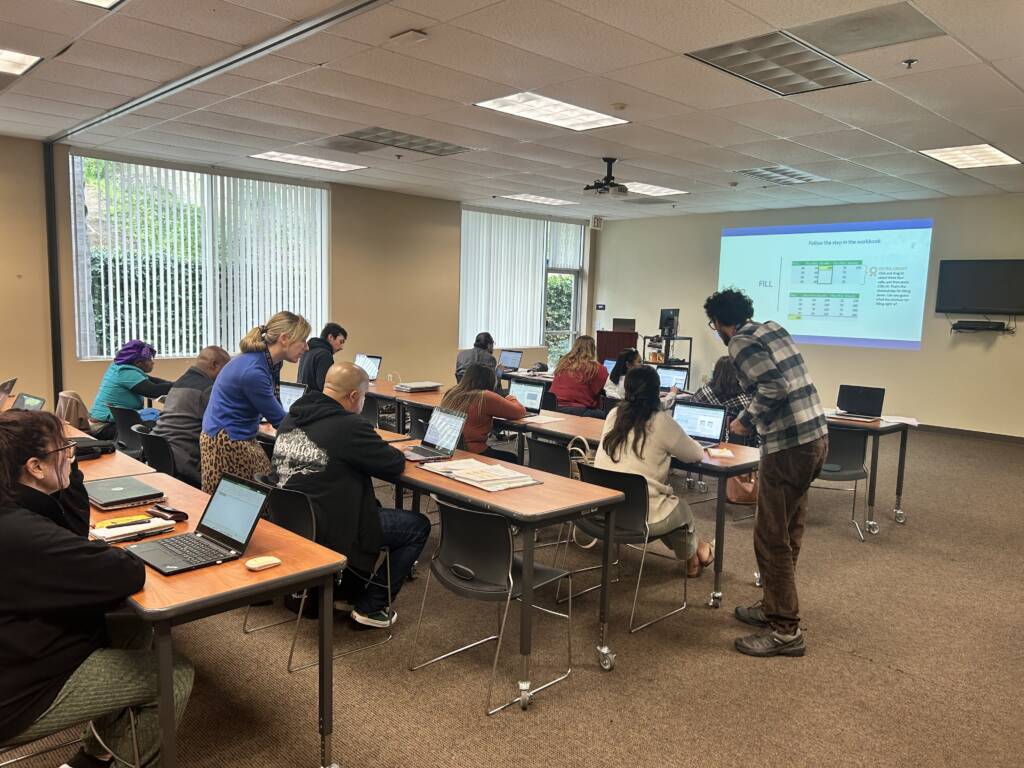 Photo of people working on laptops in a conference room