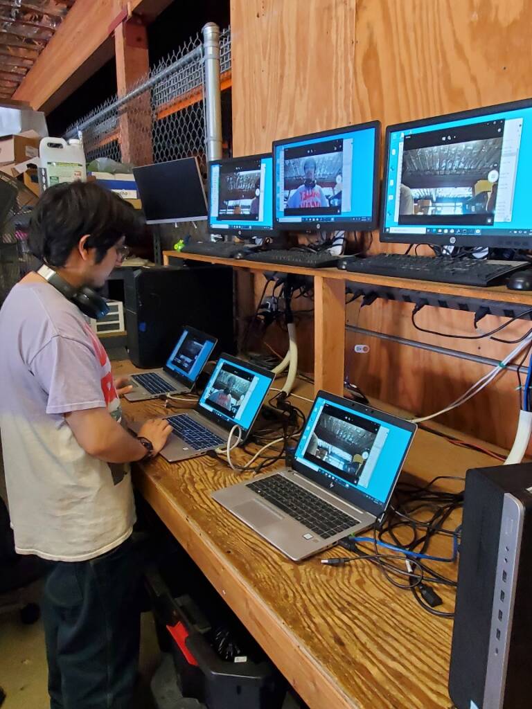 Photo of a worker examining several laptops