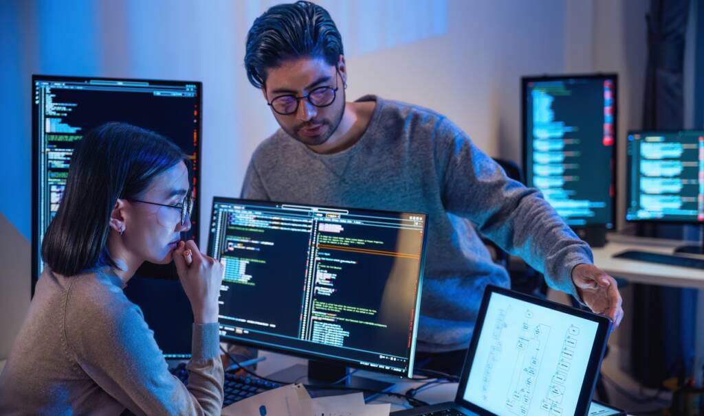 coworkers looking at a computer monitor together